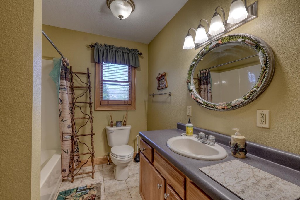 4852 Hf Lyons Road Hiawassee, GA 30546 - Photo 23 of 48 a bathroom with a granite countertop double vanity sink and a mirror