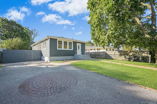 a front view of house with yard and trees in the background