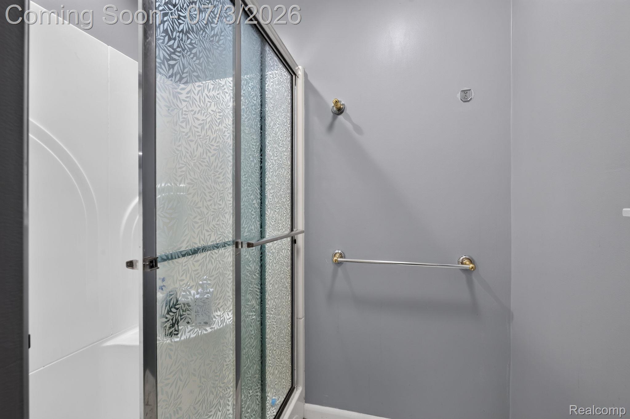 5355 North Seymour Road Flushing, MI 48433 - Photo 20 of 41 Shower enclosure featuring patterned frosted glass doors and a white surround