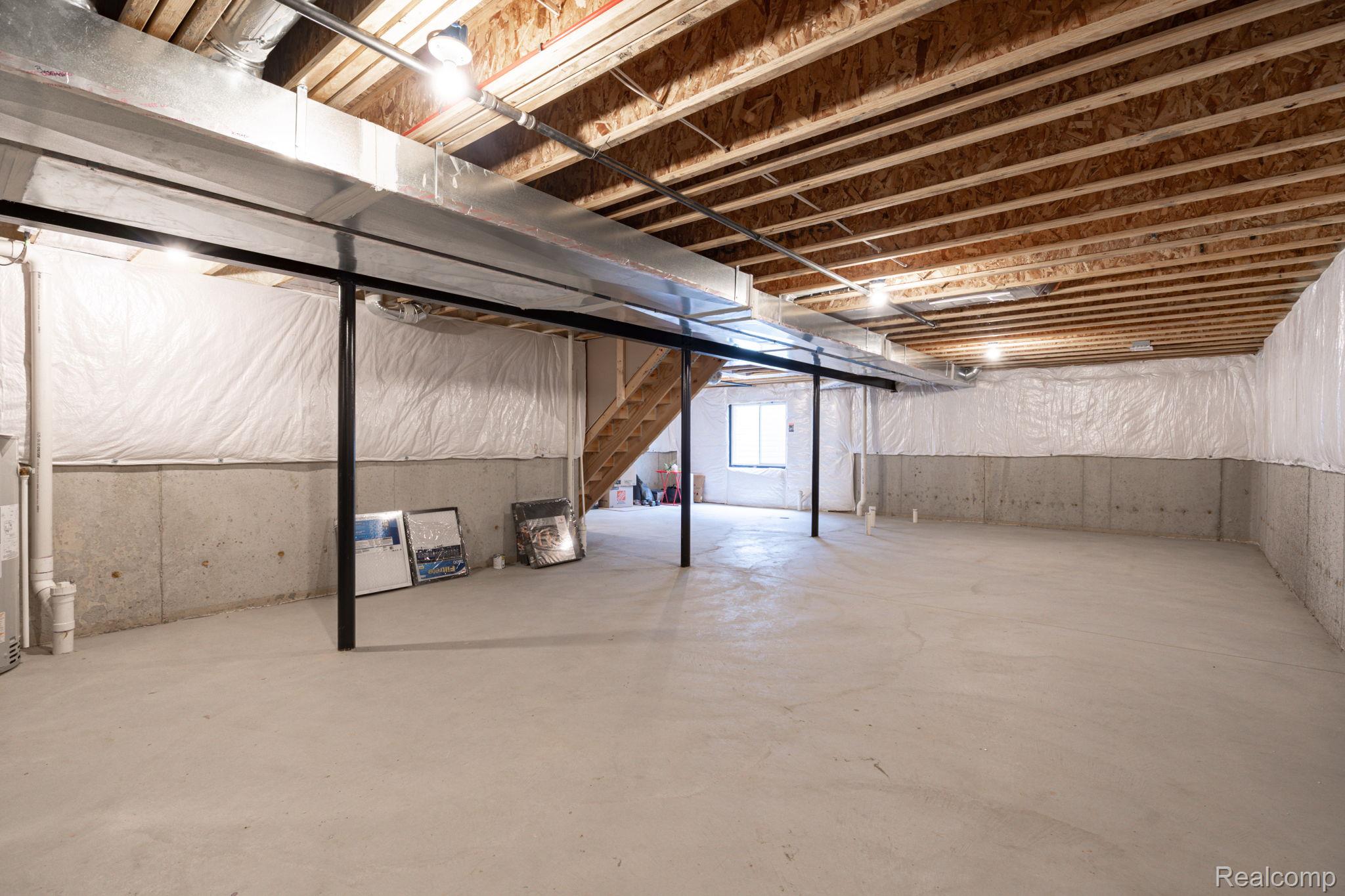 48904 Carnegie Way Macomb, MI 48042 - Photo 34 of 34 Expansive unfinished basement featuring concrete flooring, exposed wood joists, and concrete foundation walls