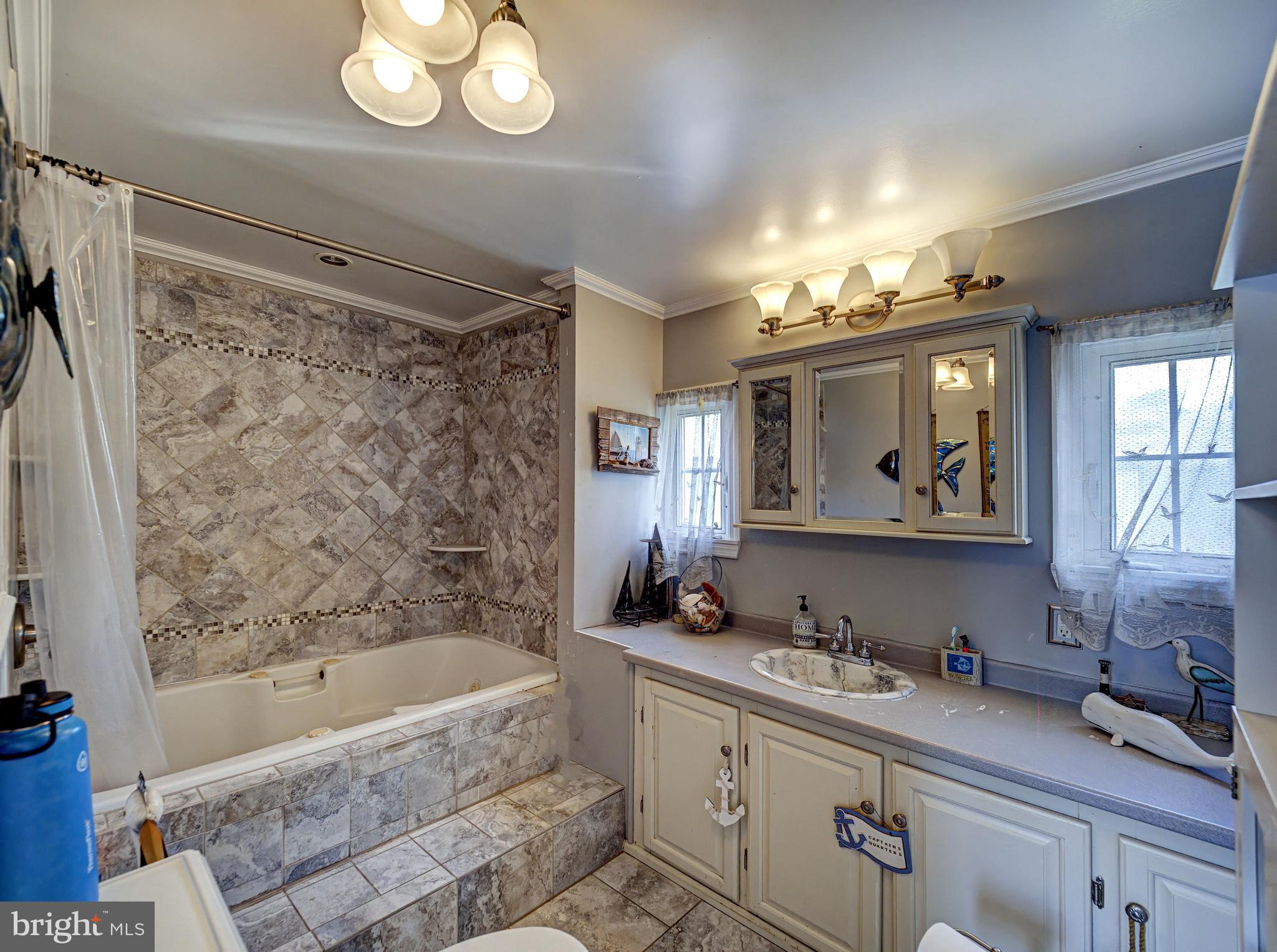 59 Bayshore Mobile Manor Hazlet, NJ 07730 - Photo 16 of 22 a bathroom with a bathtub a mirror a sink and vanity