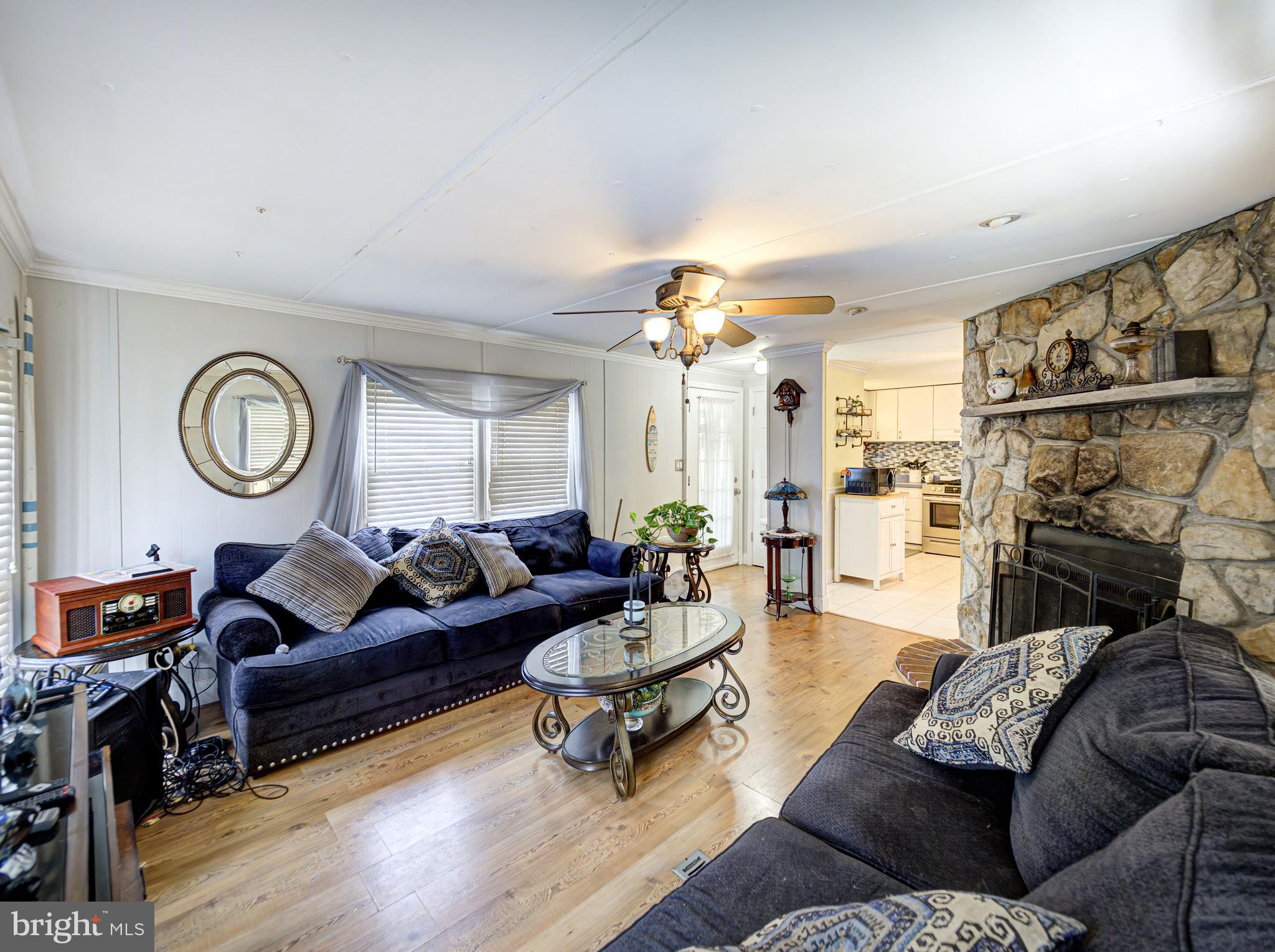 59 Bayshore Mobile Manor Hazlet, NJ 07730 - Photo 21 of 22 a living room with furniture a fireplace and a large window