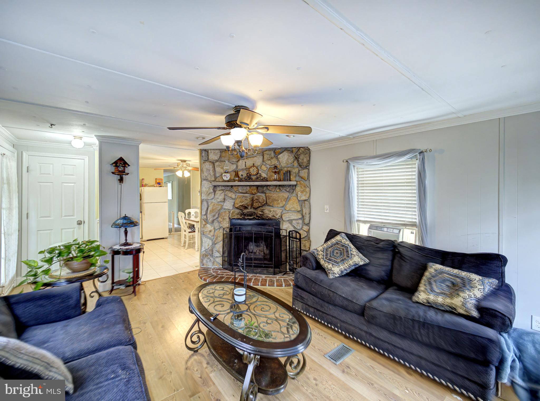 59 Bayshore Mobile Manor Hazlet, NJ 07730 - Photo 22 of 22 a living room with furniture a fireplace and a chandelier