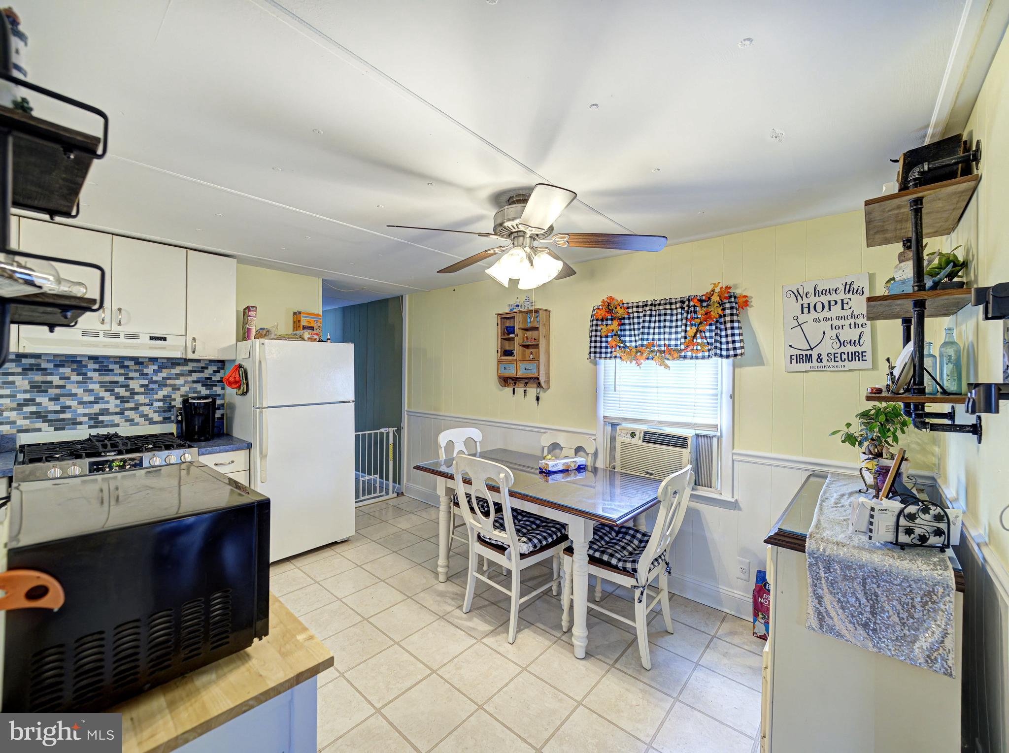 59 Bayshore Mobile Manor Hazlet, NJ 07730 - Photo 9 of 22 a kitchen with a dining table chairs and white appliances