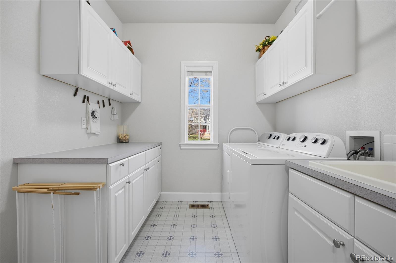 1229 Founders Circle Windsor, CO 80550 - Photo 15 of 45 a utility room with cabinets washer and dryer