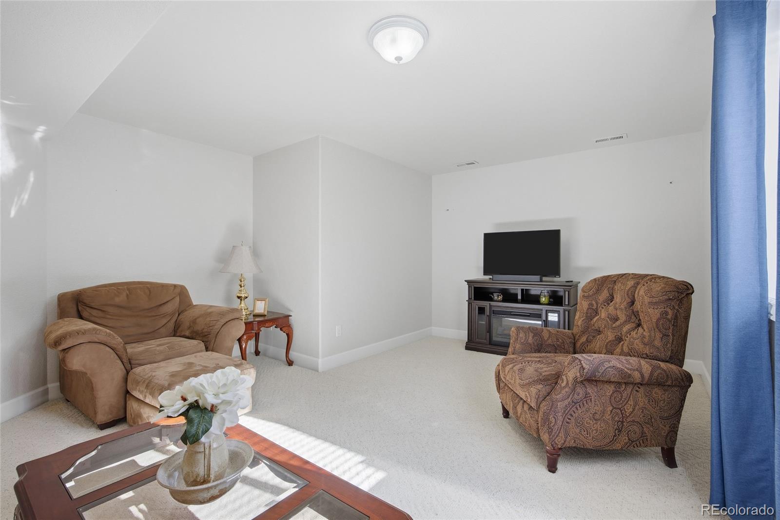 1229 Founders Circle Windsor, CO 80550 - Photo 29 of 45 a living room with furniture and a flat screen tv