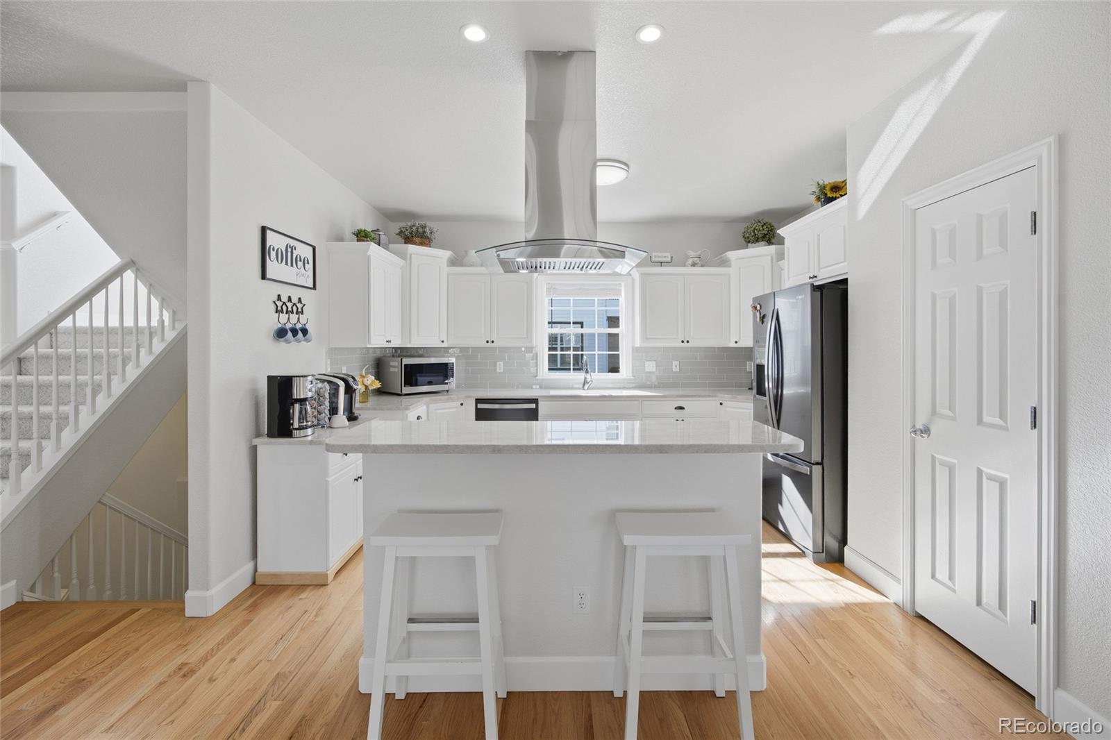 1229 Founders Circle Windsor, CO 80550 - Photo 7 of 45 a kitchen with stainless steel appliances a dining table chairs refrigerator and sink