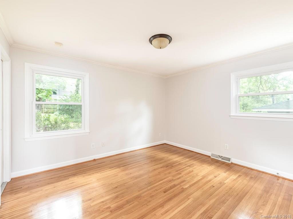 4801 Fairheath Road Charlotte, NC 28210 - Photo 14 of 25 an empty room with wooden floor and windows