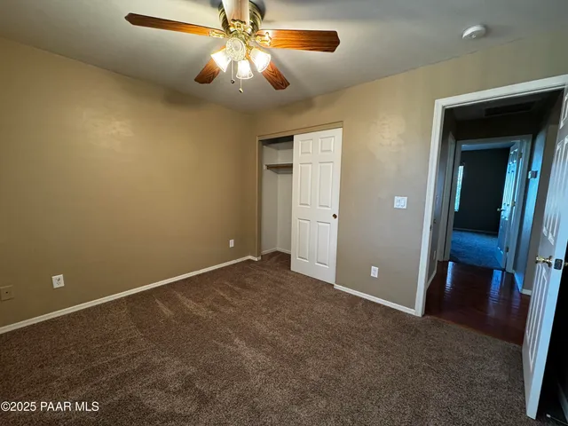 a view of an empty room with a chandelier fan