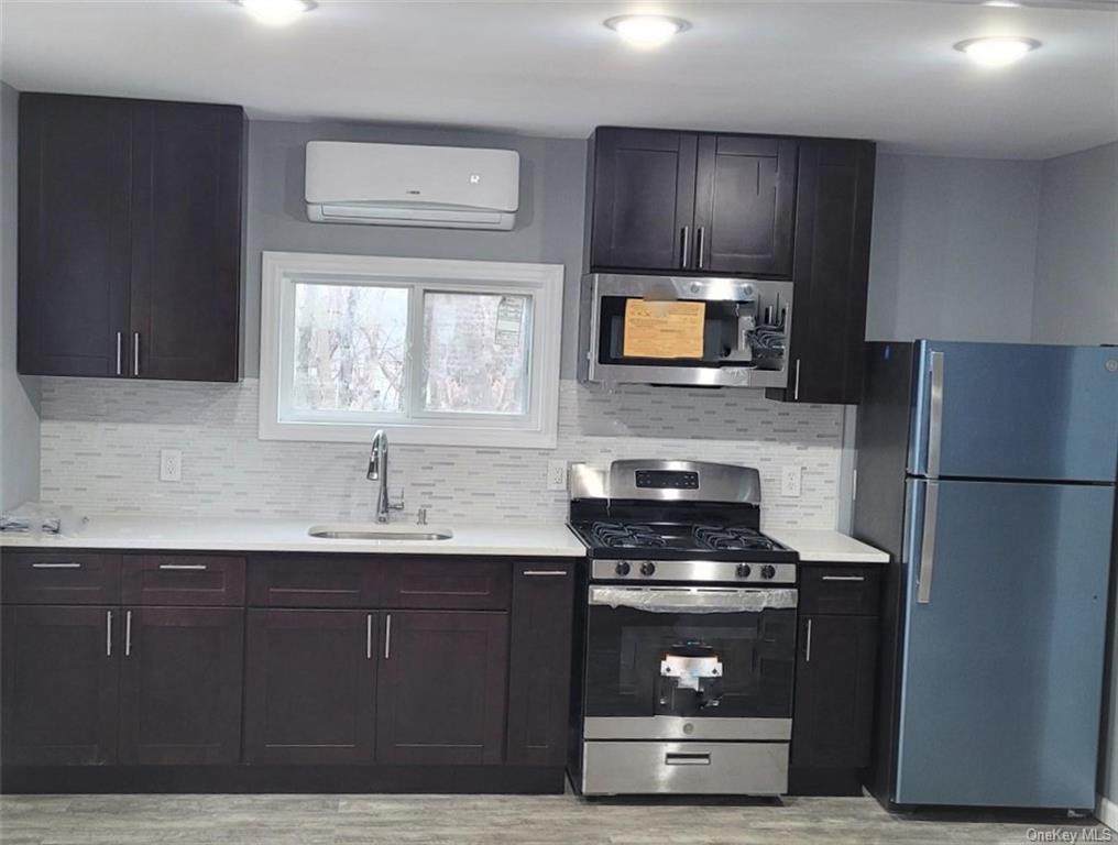 a kitchen with sink a microwave a refrigerator and cabinets