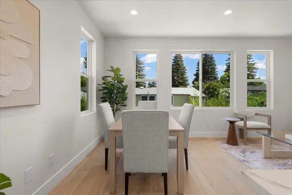 a view of a dining room with furniture and potted plant