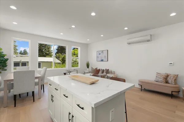 a kitchen with stainless steel appliances kitchen island granite countertop a sink refrigerator and cabinets