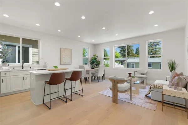 a kitchen with stainless steel appliances kitchen island granite countertop a table and chairs in it