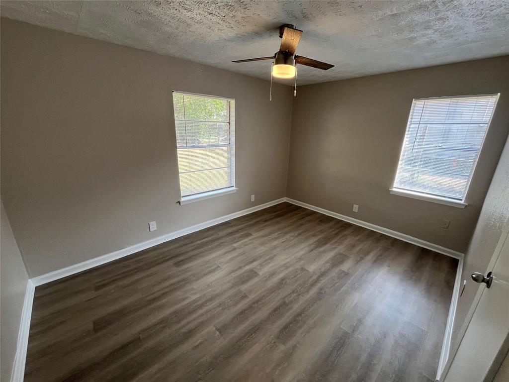 14207 Cimarron Drive Balch Springs, TX 75180 - Photo 12 of 23 Spare room with dark wood finished floors, a textured ceiling, and ceiling fan