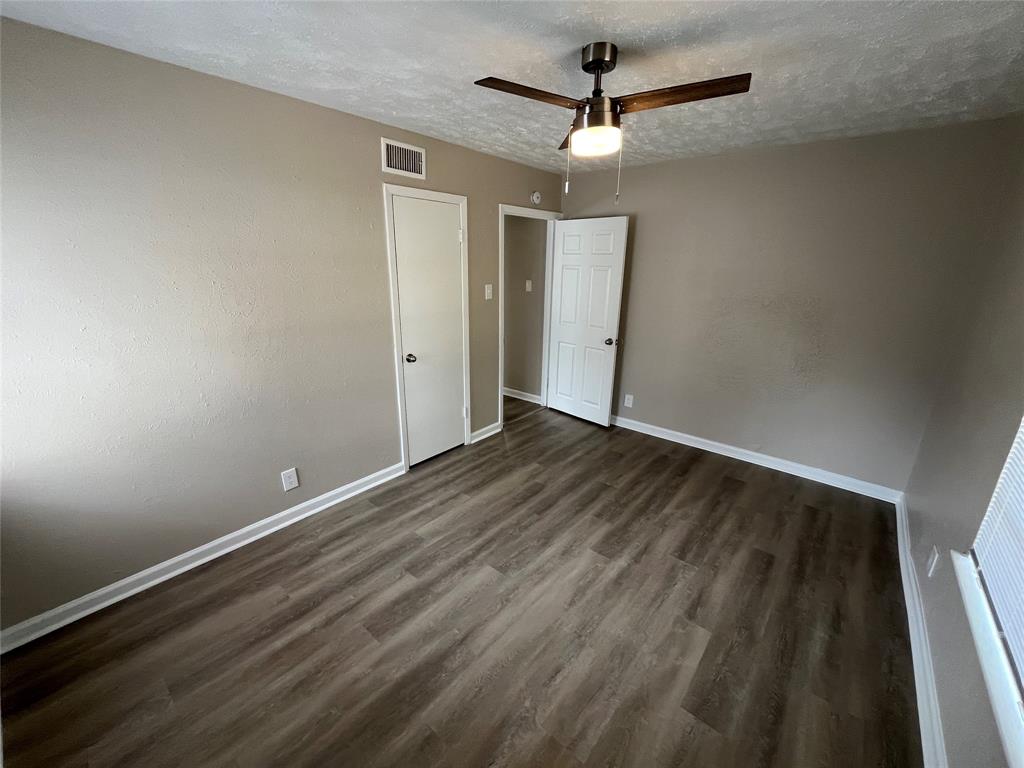 14207 Cimarron Drive Balch Springs, TX 75180 - Photo 13 of 23 Unfurnished bedroom with a textured ceiling, dark wood-style flooring, and ceiling fan