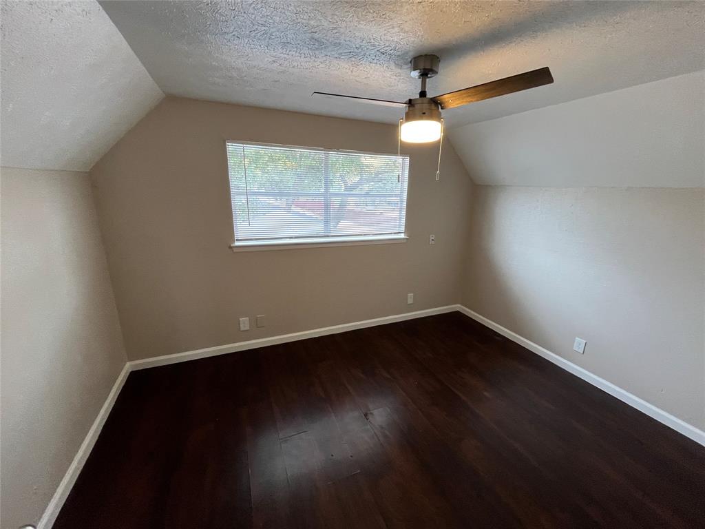 14207 Cimarron Drive Balch Springs, TX 75180 - Photo 14 of 23 Bonus room featuring a textured ceiling, lofted ceiling, dark wood-style flooring, and a ceiling fan