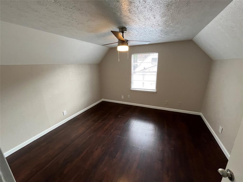14207 Cimarron Drive Balch Springs, TX 75180 - Photo 16 of 23 Additional living space with a textured ceiling, vaulted ceiling, dark wood-type flooring, and ceiling fan