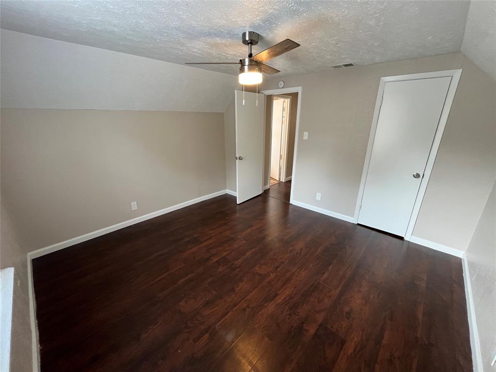 14207 Cimarron Drive Balch Springs, TX 75180 - Photo 17 of 23 Additional living space featuring vaulted ceiling, a textured ceiling, dark wood-type flooring, and a ceiling fan