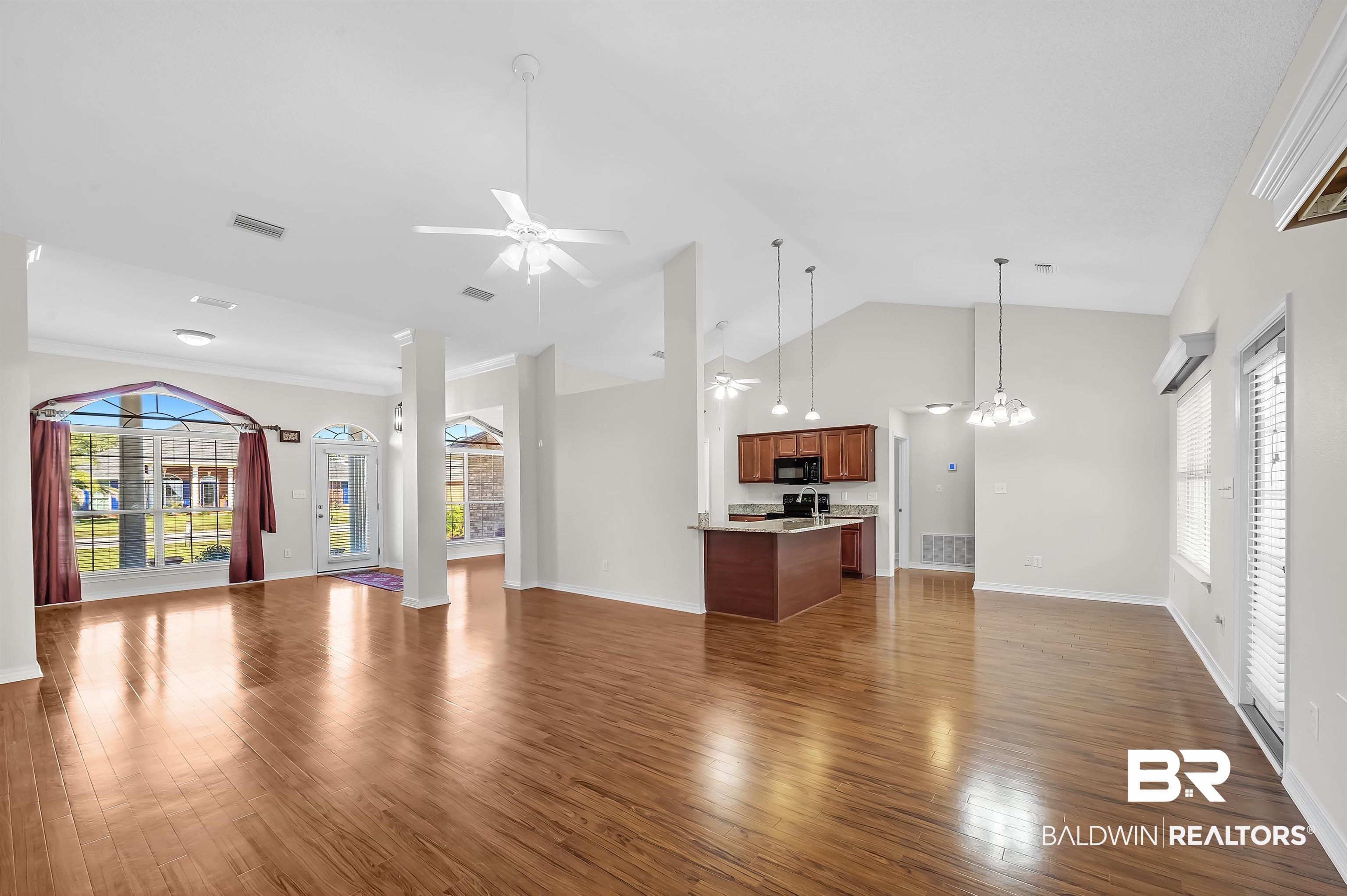 421 Collinwood Loop Foley, AL 36535 - Photo 21 of 62 Unfurnished living room with ceiling fan with notable chandelier, high vaulted ceiling, and dark hardwood / wood-style floors