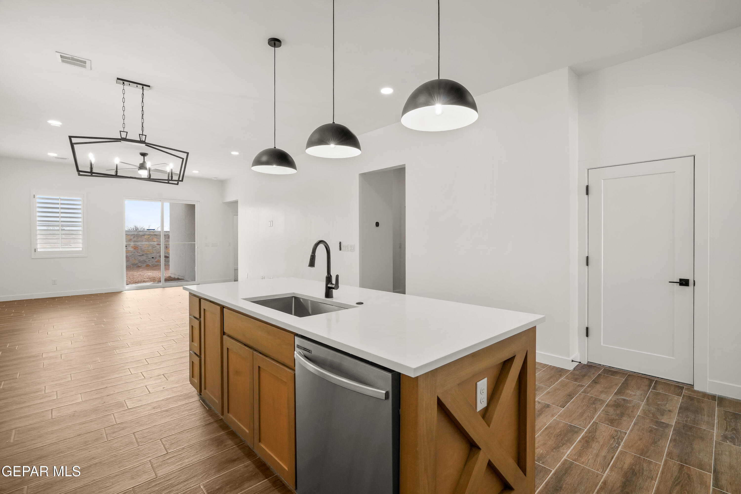 15212 Resolve Drive El Paso, TX 79938 - Photo 7 of 35 a kitchen with a sink chandelier and wooden floor
