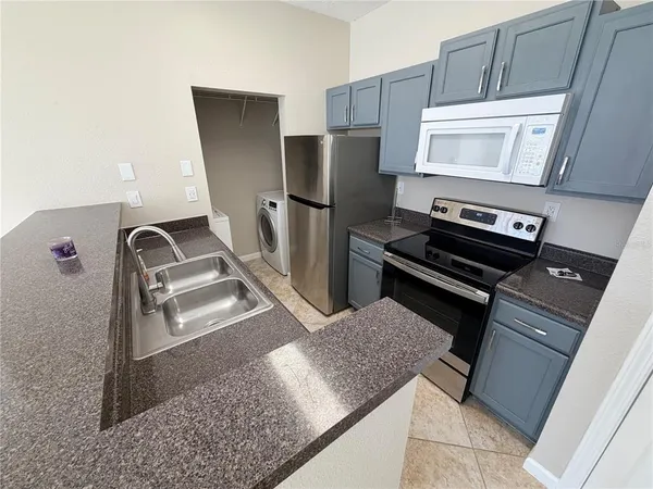 a kitchen with stainless steel appliances granite countertop a refrigerator and a stove