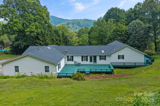 a view of a yard in front of a house with large trees