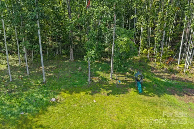 a aerial view of a house with swimming pool next to a big yard