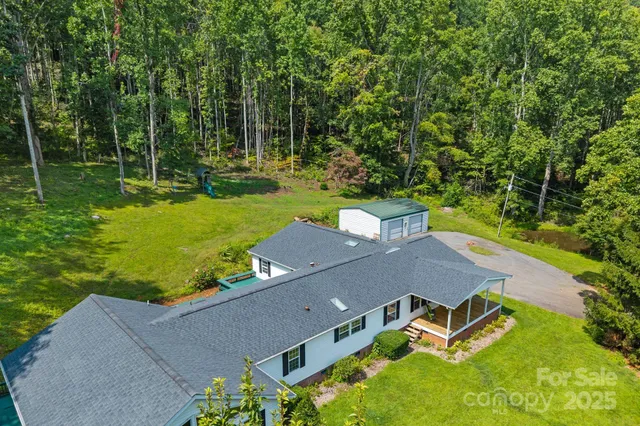 a view of a lush green forest with trees and some houses