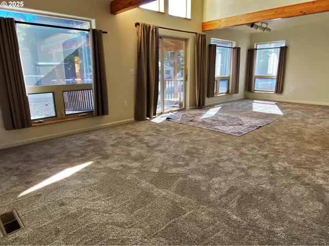 a view of a big room with wooden floor and balcony