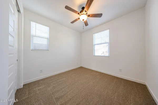 an empty room with a ceiling fan and a window