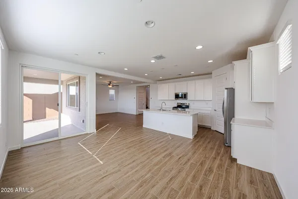 a large kitchen with stainless steel appliances kitchen island a large counter top and a wooden floors
