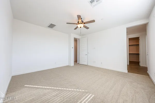 an empty room with a window and a ceiling fan
