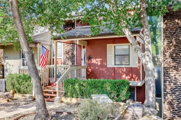 a front view of a house with a tree