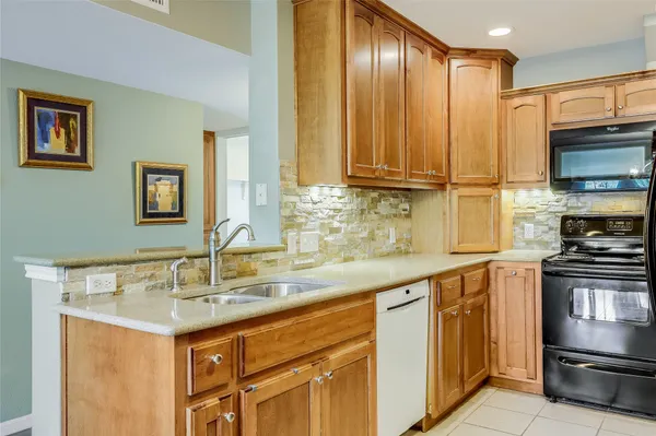 a kitchen with stainless steel appliances granite countertop a sink stove and cabinets