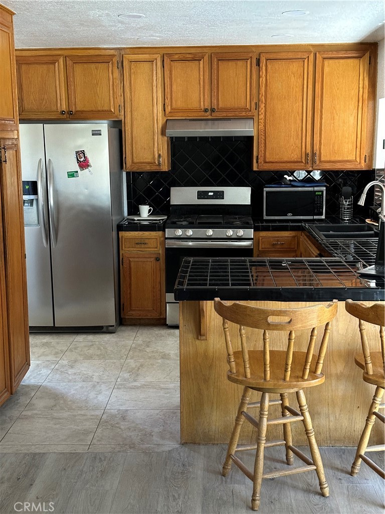37923 Amethyst Street Palmdale, CA 93552 - Photo 5 of 34 a kitchen with stainless steel appliances a stove a sink and a microwave