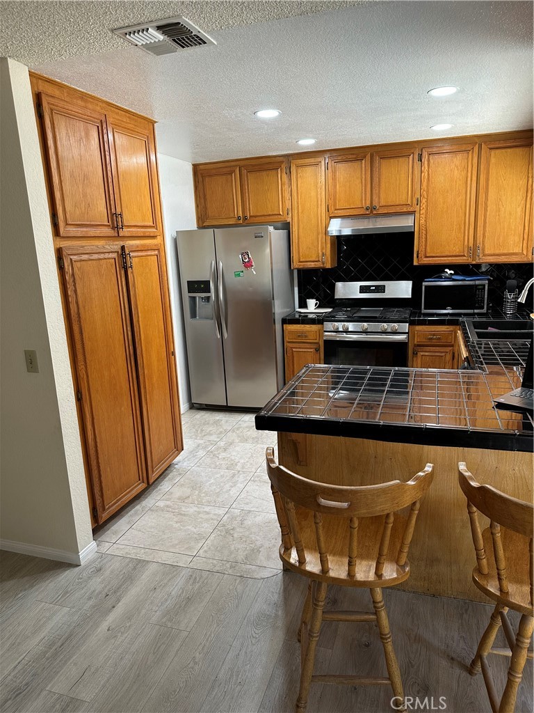 37923 Amethyst Street Palmdale, CA 93552 - Photo 7 of 34 a kitchen with stainless steel appliances a refrigerator a stove a sink and a refrigerator