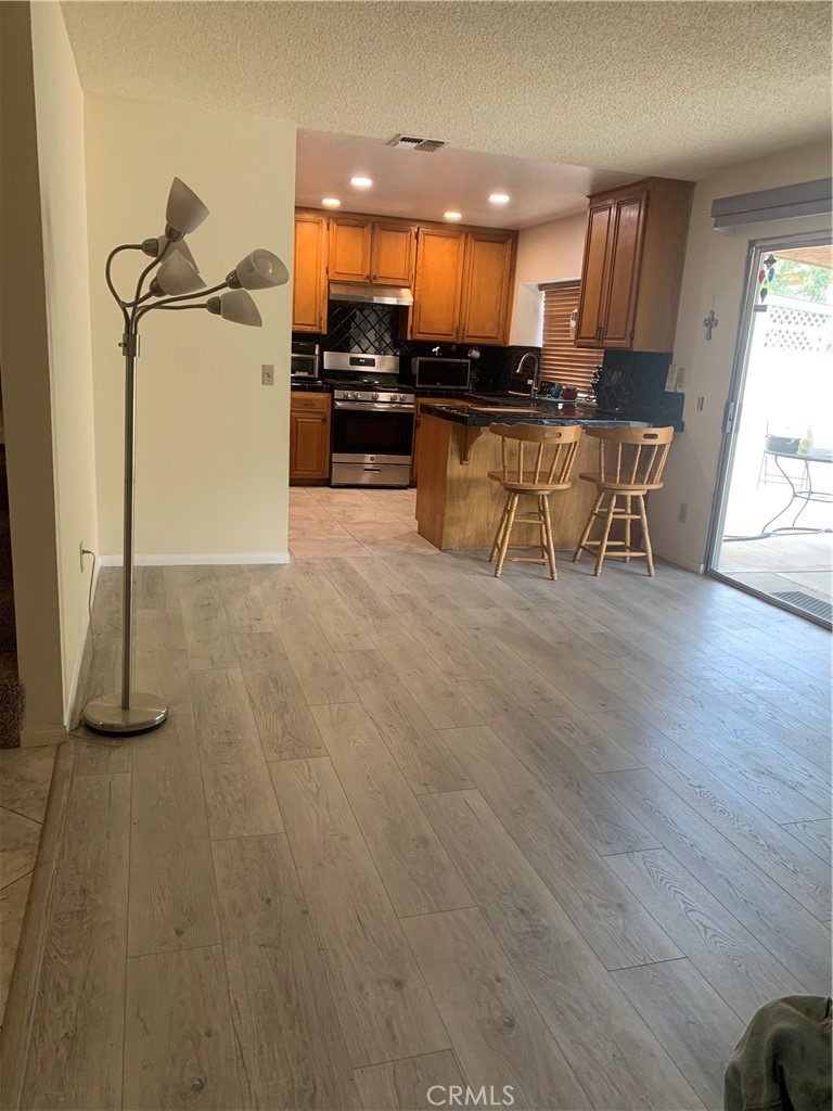37923 Amethyst Street Palmdale, CA 93552 - Photo 9 of 34 a kitchen with stainless steel appliances a refrigerator a stove a sink and a microwave