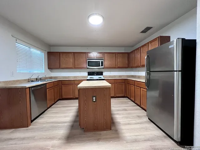 a kitchen with wooden cabinets a sink and a stove