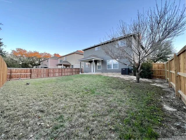 a view of a house with backyard and trees