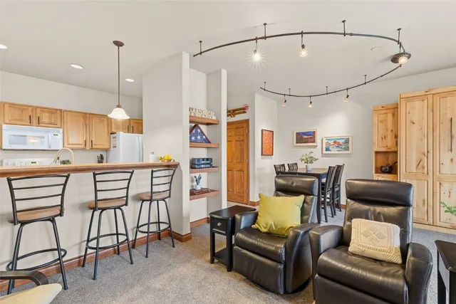 a kitchen with stainless steel appliances kitchen island granite countertop a table and chairs with wooden floor