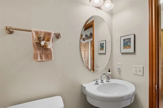 a bathroom with a toilet sink and mirror