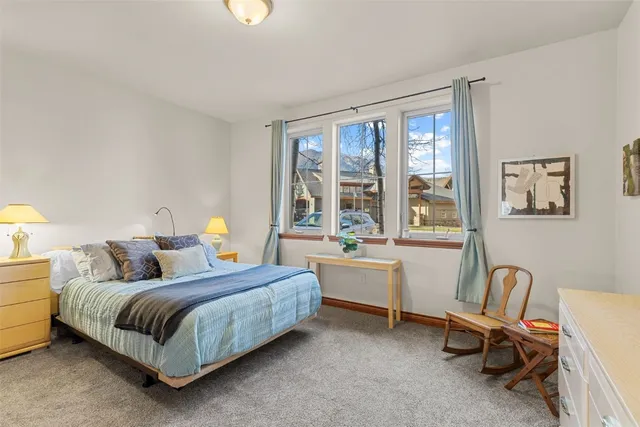 a bedroom with a bed chair and a window