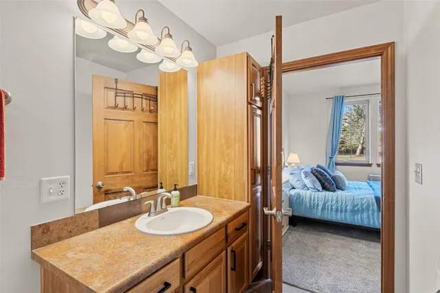a bathroom with a granite countertop sink a mirror and a bathtub