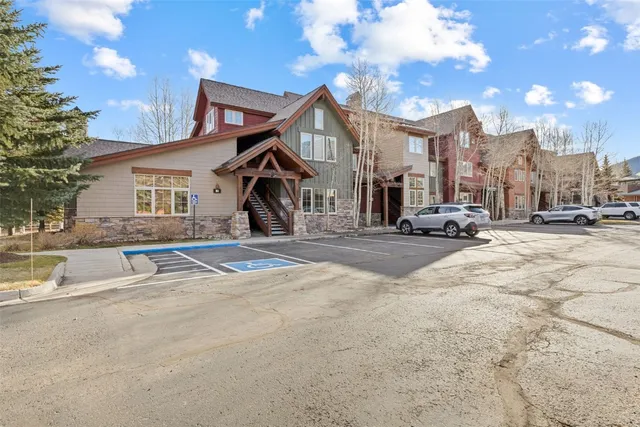 a view of a house with a big yard and large trees