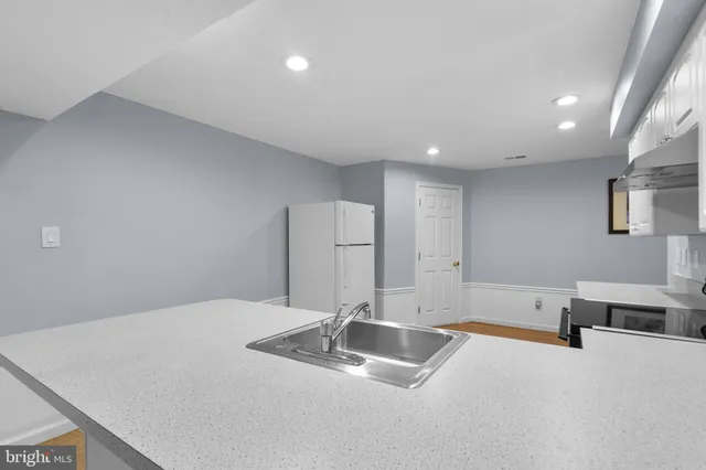 a kitchen with stainless steel appliances a sink and a refrigerator