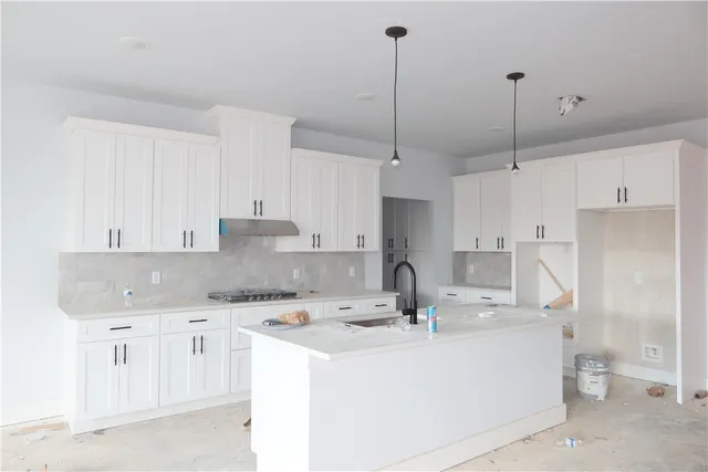 a kitchen with kitchen island a sink stainless steel appliances and cabinets