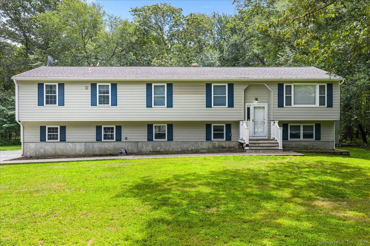a view of house with a yard
