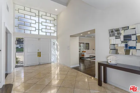 a large kitchen with stainless steel appliances granite countertop wooden cabinets a stove a sink and a large window