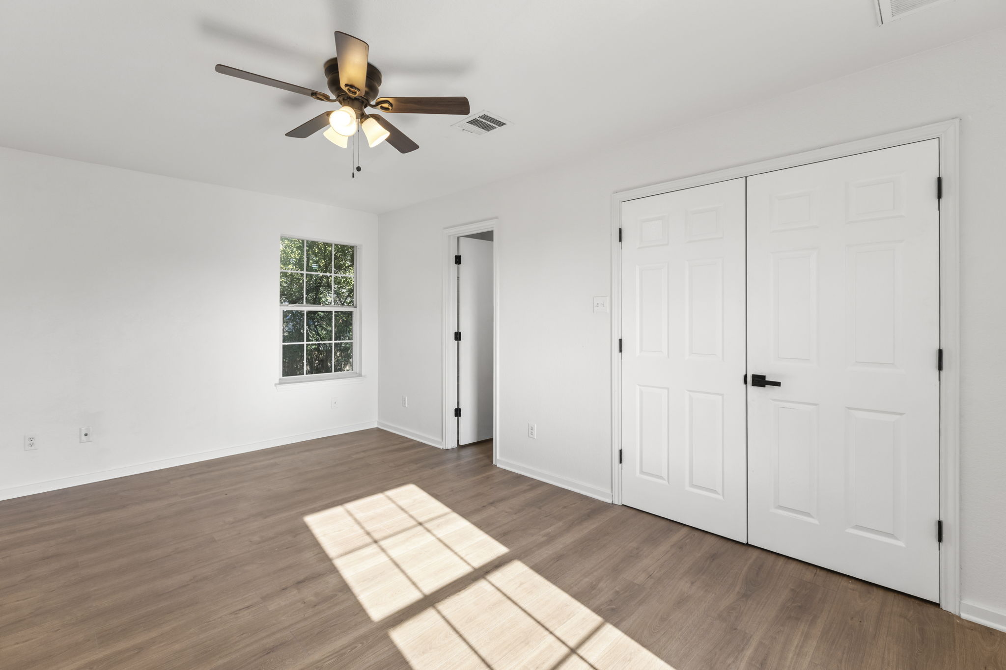 2110 Nogales Trail Austin, TX 78744 - Photo 20 of 37 a view of an empty room with wooden floor and a ceiling fan