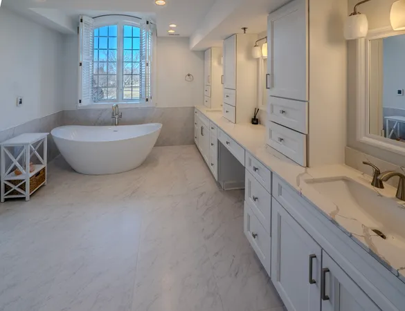 a spacious bathroom with a double vanity sink a mirror and a bathtub